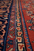 Load image into Gallery viewer, Close-up of a patterned rug showing red, navy blue, beige, and light blue woven floral and geometric borders.