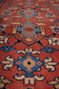 Load image into Gallery viewer, Close-up of a patterned rug with a red-orange field and blue, beige, and cream geometric floral motifs.