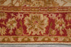 Load image into Gallery viewer, A close-up of a patterned rug showing a traditional floral medallion design in red, beige, and olive green tones.