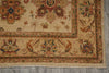 Load image into Gallery viewer, A close-up of a traditional patterned rug showing its beige base with intricate floral and geometric motifs in red, green, and blue, laid out on a gray wood floor.