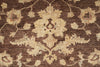 Load image into Gallery viewer, A close-up of a traditional patterned rug featuring a central floral medallion and scrolling vine motifs in cream and light beige on a dark brown background.