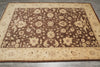 Load image into Gallery viewer, A rectangular area rug with an ornate floral and vine pattern, featuring a dark brown center field and a beige border, laid out on a gray tiled floor.