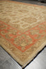 Load image into Gallery viewer, A traditional oriental-style area rug with a beige center and a rust-red border, laid out on a gray tiled floor.