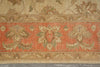 Load image into Gallery viewer, A close-up of a vintage-style area rug featuring a wide central band in muted coral orange with beige and sage green floral motifs, bordered by a beige floral field and patterned edge.