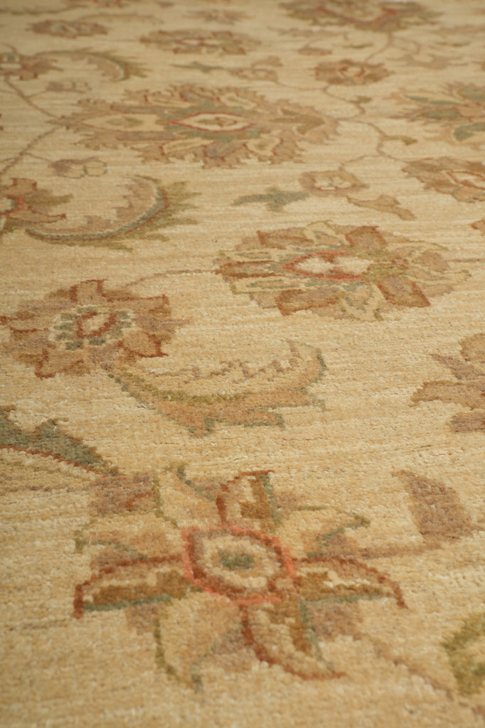 Close-up of a beige woven textile with an ornate floral and paisley pattern in muted brown, rust, and olive tones.
