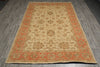 Load image into Gallery viewer, A rectangular traditional area rug with an ornate floral pattern, featuring a beige center field and rust-orange borders, laid out on a gray wood-look floor.