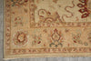 Load image into Gallery viewer, Close-up of a traditional patterned rug corner showing a beige field with floral motifs and a border in muted red, green, and cream tones.