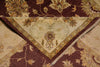 Load image into Gallery viewer, A close-up of a traditional patterned rug showing its corner and fringe detail. The design features a deep burgundy background with a cream-colored central field and floral motifs in beige, gold, and muted green.