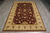 Load image into Gallery viewer, A rectangular area rug with an ornate floral pattern, featuring a dark brown center field and a beige border, laid out on a gray wood-look floor.