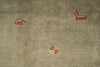 Load image into Gallery viewer, A close-up of a textured beige fabric with small red embroidered motifs, including a camel-like figure near the top right and a small geometric symbol near the bottom center.