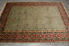 Load image into Gallery viewer, A rectangular area rug with a beige center field and a detailed red, green, and black geometric border, laid flat on a gray floor.