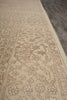 Load image into Gallery viewer, Close-up of a beige and tan patterned area rug with an ornate traditional floral design, shown on a dark gray floor.