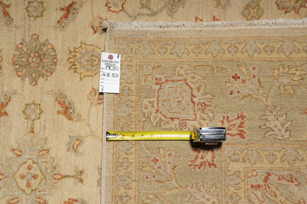 A square area rug with a traditional floral pattern in beige, rust red, and muted blue, shown with a yellow tape measure and a white product tag.