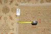 Load image into Gallery viewer, A square area rug with a traditional floral pattern in beige, rust red, and muted blue, shown with a yellow tape measure and a white product tag.