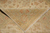 Load image into Gallery viewer, A close-up of a folded area rug showing its intricate traditional pattern in beige, muted green, and terracotta red.