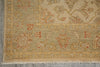 Load image into Gallery viewer, A close-up of an area rug showing its corner and fringe, featuring a traditional floral pattern in beige, muted green, and terracotta orange.