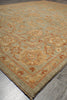 Load image into Gallery viewer, A close-up of a traditional patterned area rug with a beige and light blue-gray base, decorated with warm orange and brown floral motifs.