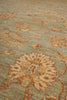 Load image into Gallery viewer, Close-up of a textured area rug featuring a traditional floral pattern in warm beige and rust orange tones over a muted sage green background.