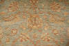 Load image into Gallery viewer, A close-up of a traditional patterned rug with a muted sage green background and warm beige and rust floral motifs.