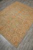 Load image into Gallery viewer, An area rug with an intricate floral and paisley pattern in muted sage green, tan, and rust orange, shown laid out on a gray wood-look floor.