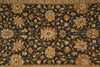 Load image into Gallery viewer, An ornate traditional area rug with a dark black background and intricate floral motifs in beige, gold, and muted orange, featuring a decorative border.