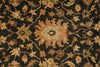 Load image into Gallery viewer, A close-up of a traditional patterned rug with a dark charcoal background and a central floral medallion in muted orange, beige, and brown tones.