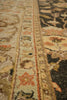 Load image into Gallery viewer, Close-up of an ornate patterned rug with a cream base and traditional motifs in rust, olive green, black, and tan.