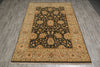 Load image into Gallery viewer, A rectangular area rug with a traditional floral pattern, featuring a dark central field surrounded by a wide beige and orange border, laid out on a gray wood-look floor.