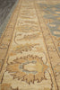 Load image into Gallery viewer, Close-up of an ornate patterned area rug with beige, tan, muted blue, and brown woven motifs.