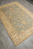 Load image into Gallery viewer, A rectangular area rug with a traditional floral and botanical pattern, shown at an angle on a gray wood-look floor. The rug features a muted sage green center field, beige borders, and golden-yellow floral motifs.