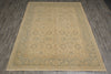 Load image into Gallery viewer, A rectangular area rug with a distressed traditional pattern in beige and muted sage green, laid flat on a dark gray wood-look floor.