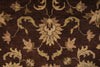 Load image into Gallery viewer, A close-up of a traditional patterned rug featuring a dark brown background with beige, tan, and muted green floral and vine motifs.