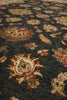 Load image into Gallery viewer, Close-up of a traditional patterned rug with a dark charcoal gray background and floral motifs in beige, rust red, and muted green.