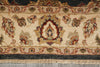Load image into Gallery viewer, Close-up of an ornate area rug with a cream background, featuring a central medallion and floral motifs in muted red, green, and brown tones, finished with a fringed edge.
