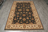 Load image into Gallery viewer, A traditional oriental area rug with a dark navy blue central field and beige borders, featuring intricate floral and medallion patterns in brown, gold, and cream, laid out on a gray wood-look floor.