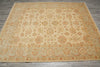 Load image into Gallery viewer, A large rectangular area rug with an intricate traditional floral and medallion pattern in beige, cream, and rust orange, laid out on a gray wood floor.