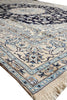 Load image into Gallery viewer, A close-up of a traditional oriental rug with a cream base, navy blue central field, and light blue and beige floral motifs.