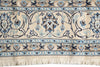 Load image into Gallery viewer, Close-up of a patterned area rug with a cream base, blue and navy floral motifs, and a fringed edge.