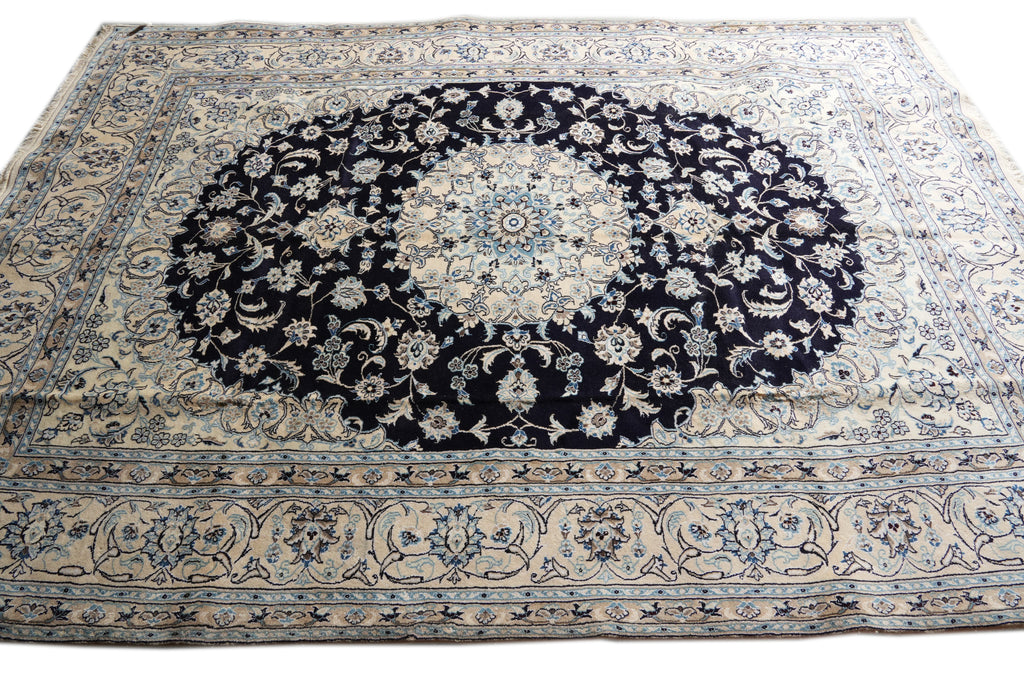 A traditional oriental area rug with a large central medallion, featuring a dark navy blue center surrounded by cream, beige, and light blue floral patterns and borders.