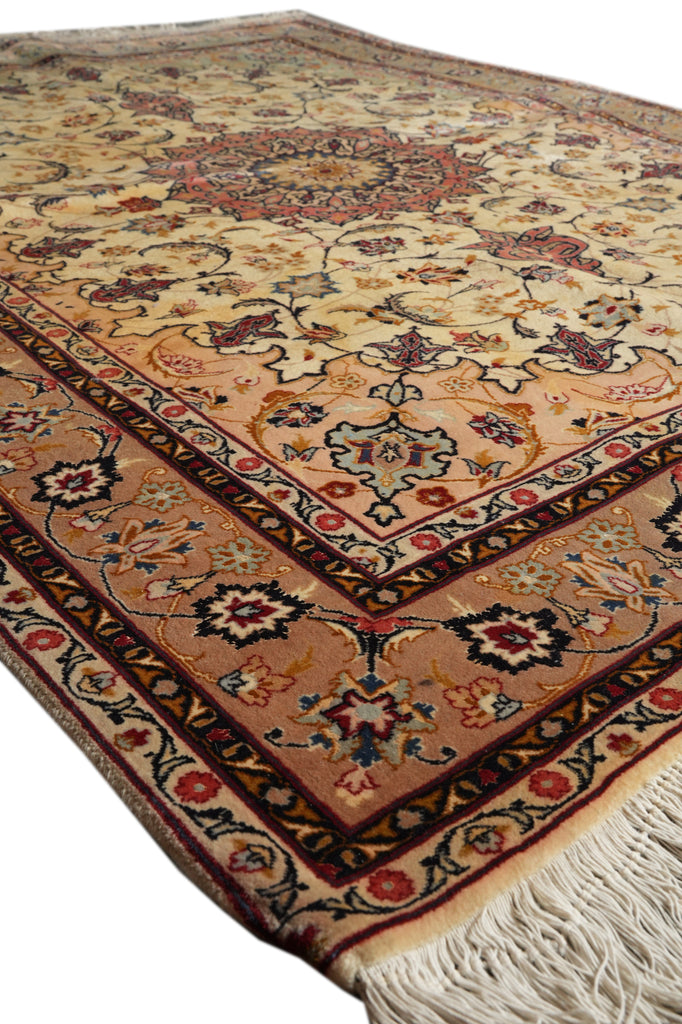 An oriental-style area rug with a traditional floral pattern, featuring a central medallion, ornate borders, and cream-colored fringe on a white background.