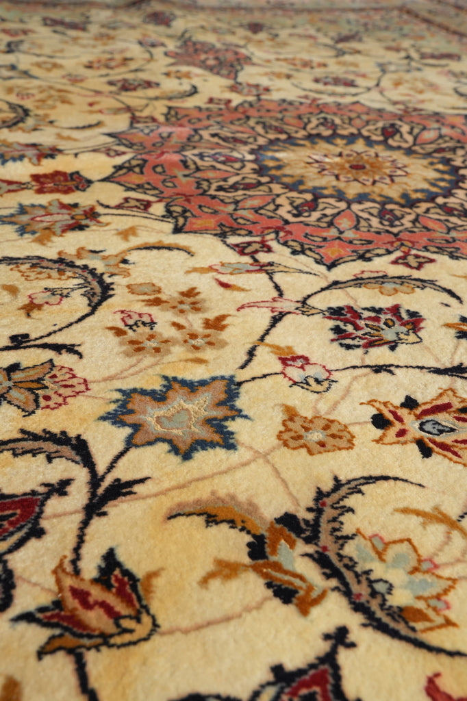 Close-up of an ornate floral patterned rug with a cream background and detailed motifs in red, blue, brown, and black.