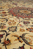 Load image into Gallery viewer, Close-up of an ornate floral patterned rug with a cream background and detailed motifs in red, blue, brown, and black.