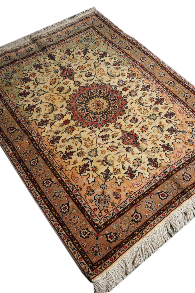 An oriental-style area rug with a traditional floral pattern, featuring a central medallion, detailed borders, and cream-colored fringe on a white background.