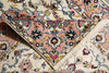 Load image into Gallery viewer, A close-up of a traditional patterned rug with cream, pink, blue, and brown floral motifs and fringed edges.