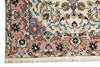Load image into Gallery viewer, A close-up of an ornate patterned rug corner showing cream, blush pink, blue, purple, and black floral motifs with fringe along the bottom edge.