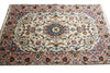 Load image into Gallery viewer, A rectangular traditional area rug with an intricate floral and medallion pattern, featuring a cream center, pink borders, and accents of blue, green, and gold.