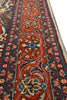 Load image into Gallery viewer, A close-up view of an ornate patterned area rug with a vibrant red center, detailed blue and beige floral motifs, and a cream-colored border.