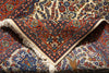 Load image into Gallery viewer, A close-up of a traditional Persian-style area rug with an intricate floral and paisley pattern in red, blue, and cream, showing the detailed weave and cream-colored fringe.