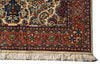 Load image into Gallery viewer, A close-up of a traditional patterned rug corner showing cream, red, navy, and orange floral motifs with a fringed edge on a white background.