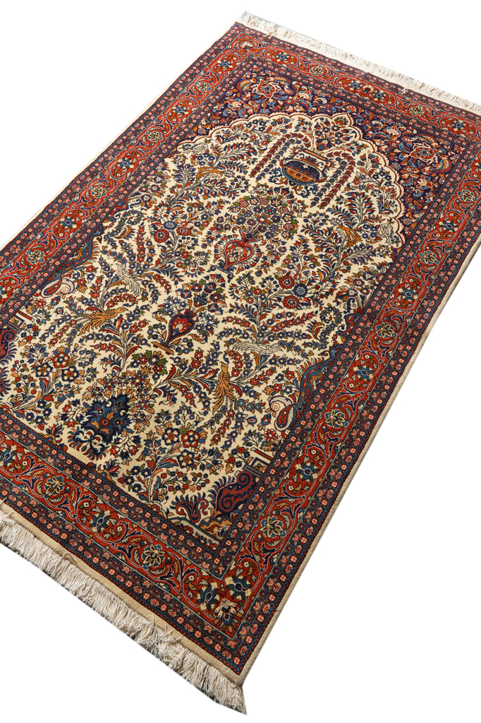 An ornate Persian-style prayer rug with a central mihrab design, featuring a cream center field, a dark red border, and blue and green floral details, shown on a white background.